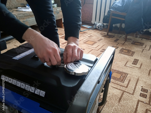 Person examines and adjusts the top of a generator in a home setting during the day