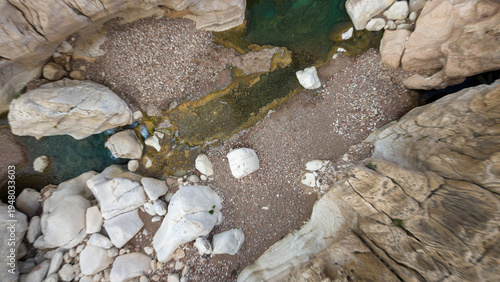 Aerial view of rocky canyon stream with turquoise pools