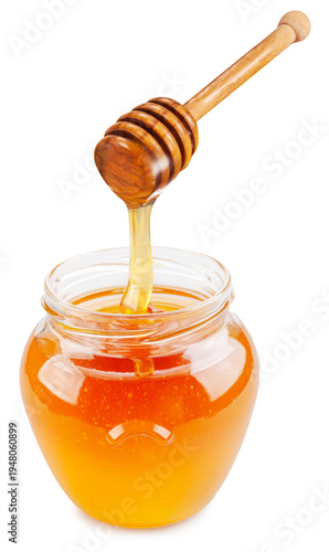 Honey dripping from honey stick into honey pot on a white background. File contains clipping path.