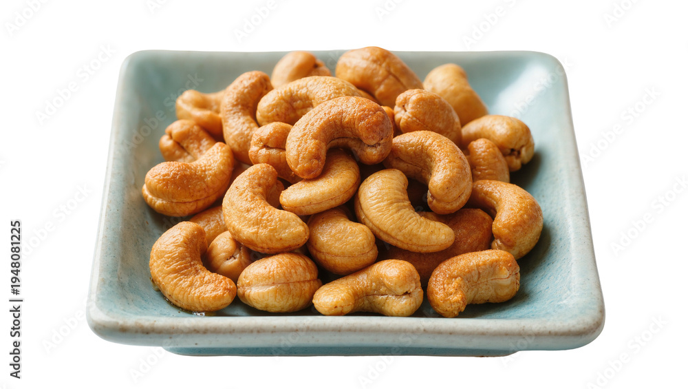 Fototapeta premium Isolated pile of delicious roasted cashew nuts in a blue ceramic dish, healthy snack food
