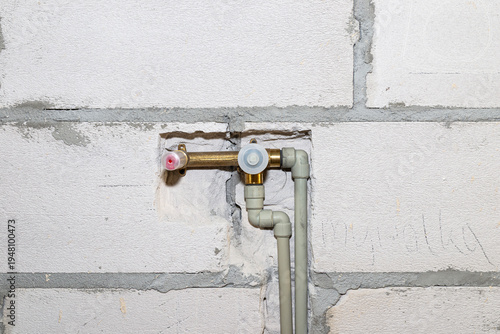 Plumbing work installing plastic pipes in concrete wall