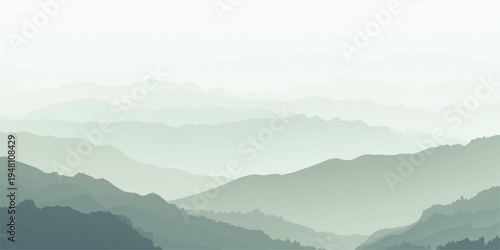 Misty mountain landscape with forest hills and a deep valley under a blue sunrise sky where fog and clouds meet the morning sun.