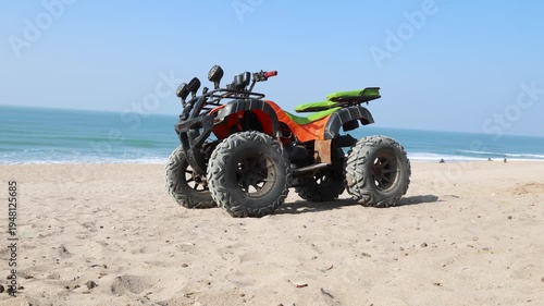 all terrain vehicle parked on sandy beach with ocean waves in background
