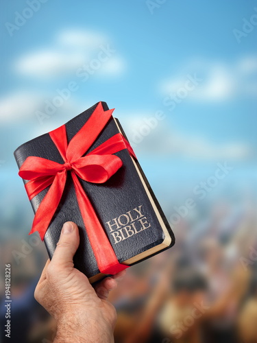 Hand Offering Holy Bible as a Gift to People Under Blue Sky