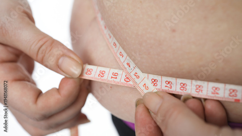 Cuadro en lienzo Close-up of plus-size female measuring waist after home workout