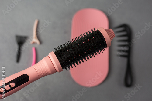 Professional pink electric hair styler set for beauty supply business. Complete kit with round brush, comb, mat, and clips in retail packaging. Perfect for small beauty shops and online stores