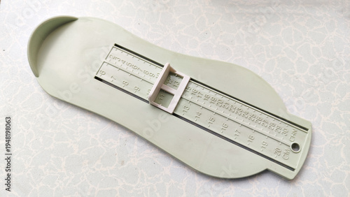 Alat ukur kaki, untuk memilih sepatu atau sandal. Plastic infant length measuring board designed for newborn and baby growth assessment, isolated on a light background with medical