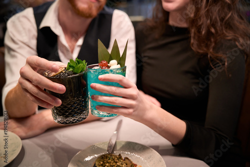 Fotografia Adult couple toasting with cocktails at sophisticated bar