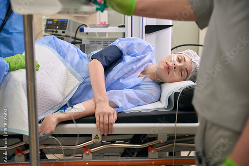 Caucasian woman unconscious in hospital recovery room