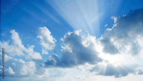 Obraz na plátně Dramatic blue sky with sun rays shining through fluffy white clouds
