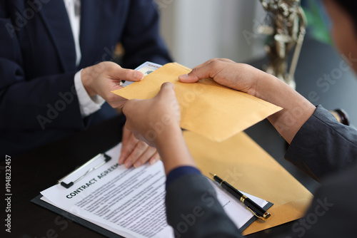 Businessman receiving bribe money in brown envelope from businesswoman at office.