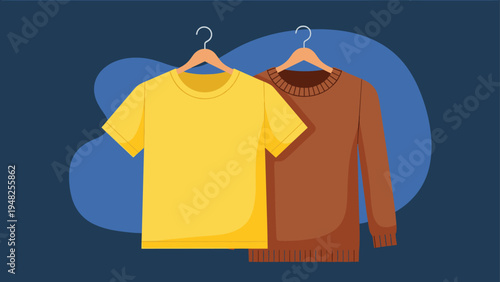 Yellow short sleeved t-shirt and a brown long sleeved sweater hanging on wooden hangers against a blue backdrop.