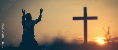 A man kneeling in prayer with raised hands before a cross.