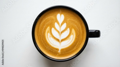 Photos Top down view of a black ceramic coffee mug filled with latte art on a white bac