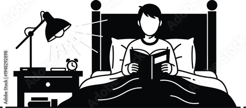 boy reading book in bed with lamp