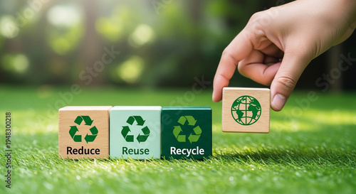 A hand placing a block with a green globe on it next to blocks with reduce, reuse, recycle.