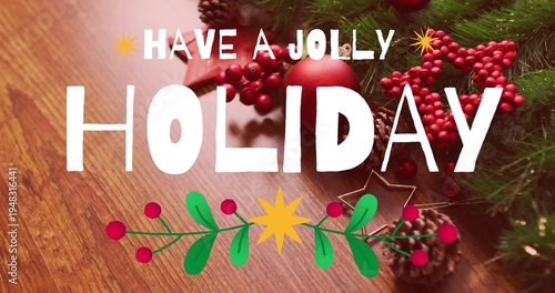 Showing white HOLIDAY and HAVE JOLLY text on wood-grain tabletop, evergreen sprigs, red ornament
