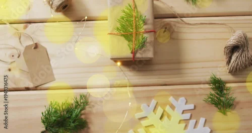 Fototapeta Displaying kraft-wrapped gift sitting on tabletop with twine spool, gift tag, snowflake, copy space