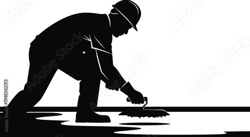 Construction worker silhouette brooming pavement surface