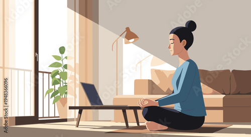 A woman with a bun meditates cross-legged on a yoga mat in a sunlit room with a laptop.