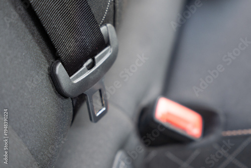 Close-up of a car seatbelt latch and strap, demonstrating essential safety features in automotive design, highlighting durability and functionality in everyday transport.