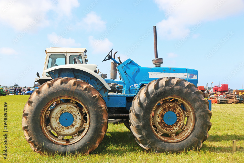 Obraz premium Vintage tractors standing in a field 