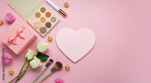 Decorative cosmetics, pink gift box and white roses on pastel pink background for Mother's Day greeting card