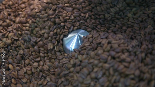 Coffee beans rotate and tumble in a roasting machine, achieving a perfect medium roast for rich flavor and aroma, representing fresh preparation - stock video