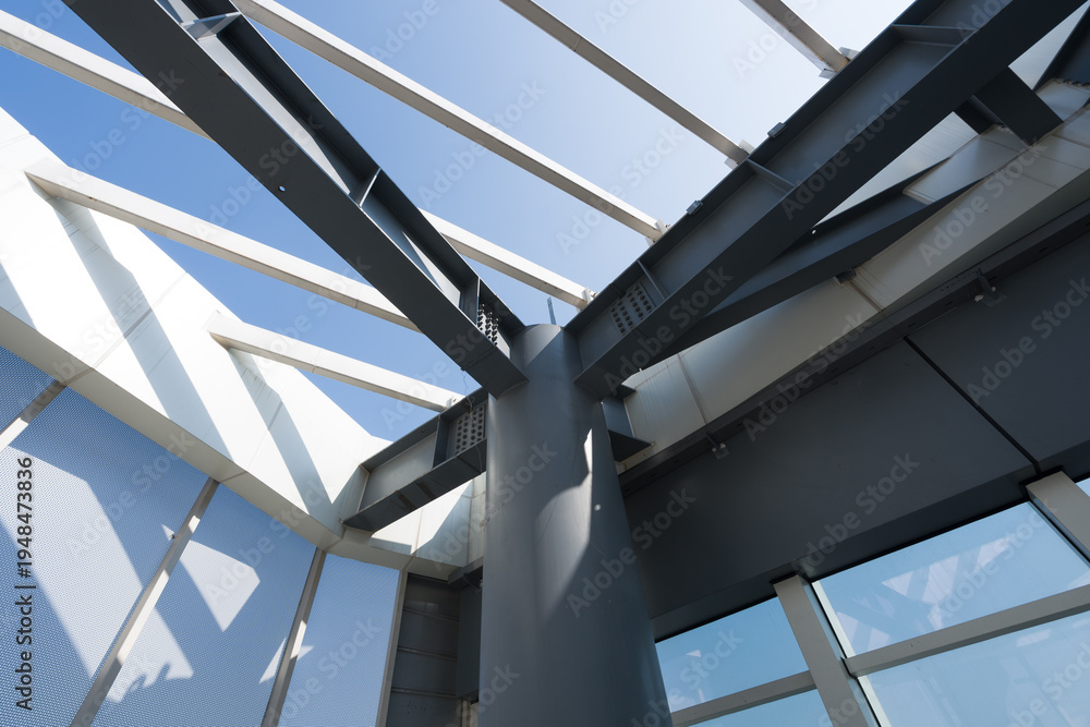 Obraz premium Modern architectural steel structure roof viewed from below with geometric beams and glass panels