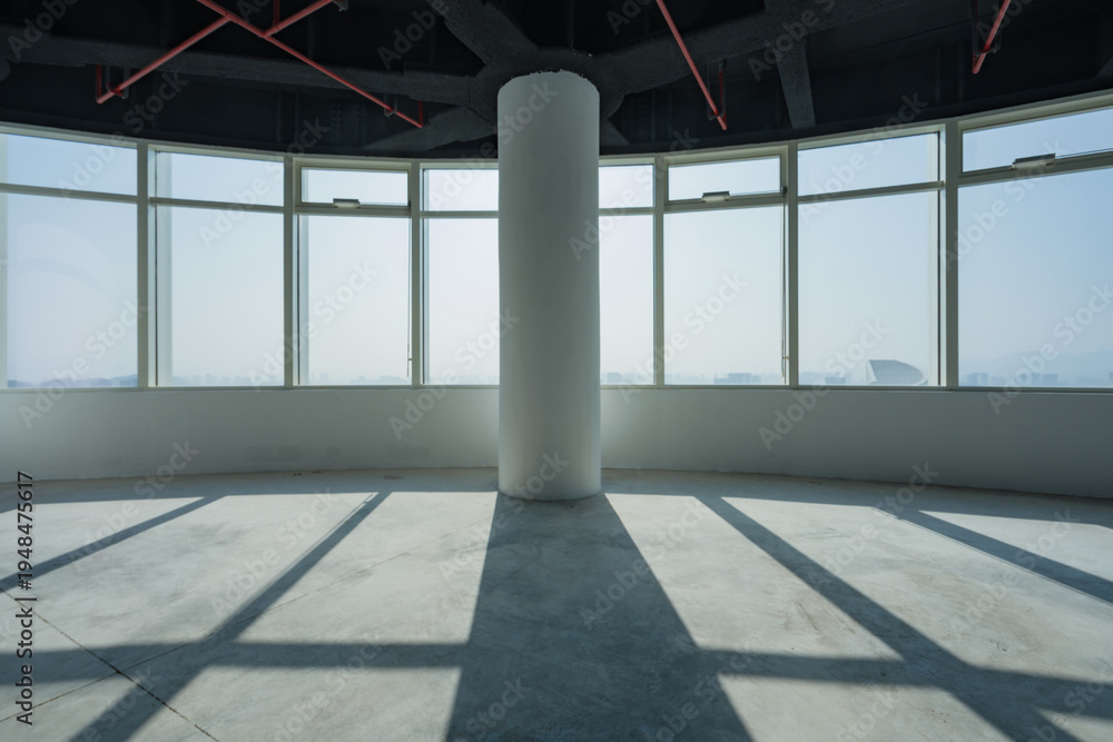 Fototapeta premium Empty modern office interior with circular floor-to-ceiling windows and central concrete column