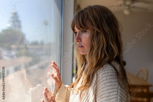 Photos Pensive woman gazing through window.