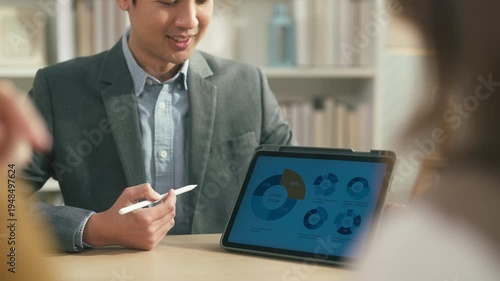 Professional financial advisor presenting investment and savings strategy to couple with tablet analytics, future wealth planning and personal finance consultation concept.	

