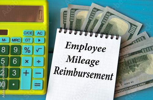 EMPLOYEE MILEAGE REIMBURSEMENT - words in a notebook against the background of a calculator and banknotes