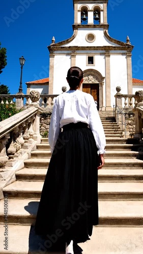 Woman walking up church stairs.