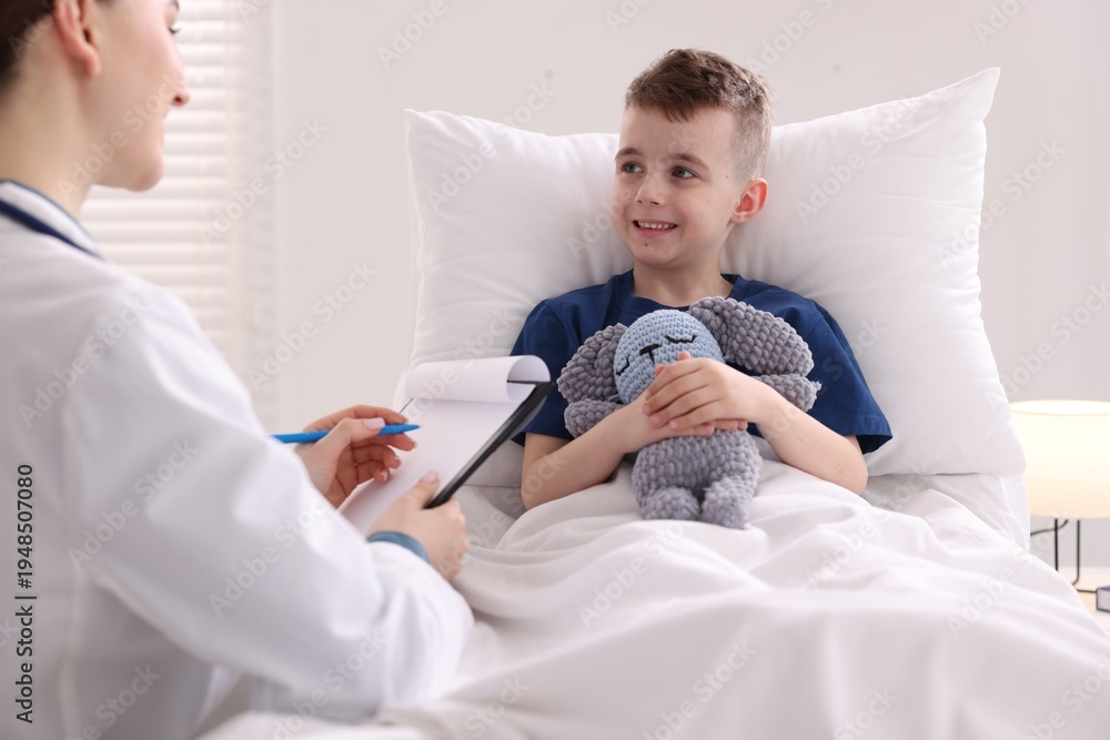 Obraz premium Doctor with clipboard examining little child in hospital, closeup