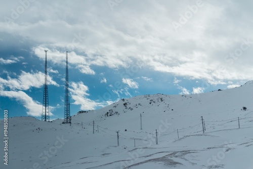 Communication Towers and Power Lines on Snowy Mountain Landscape