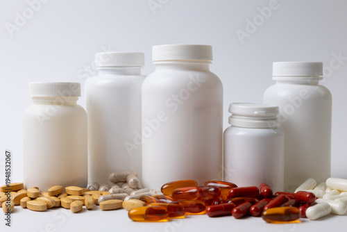 Vitamins On Neutral Background. Assorted Supplement Bottles With Capsules On Plain Backdrop