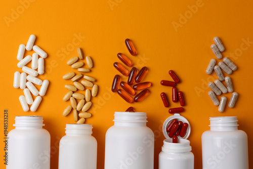 Vitamins On Neutral Background. Assorted Supplement Bottles With Capsules On Plain Backdrop