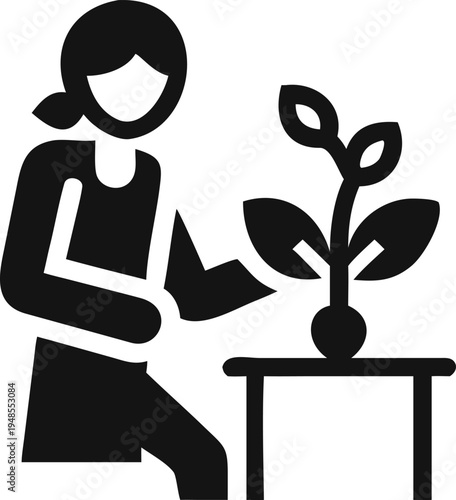Woman actively waters a small potted plant on a table with dedication and care