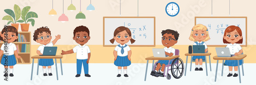 Diverse group of elementary school children in uniforms learning in a classroom with laptops including a student in a wheelchair.
