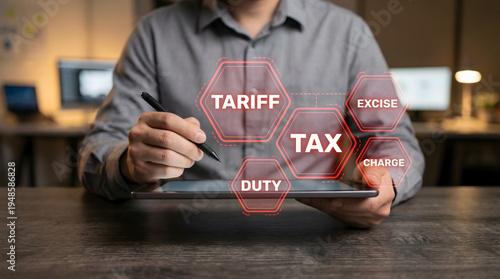 A business person uses a digital tablet and stylus interacting with virtual icons for tax tariff duty excise and charge terms on a modern office desk