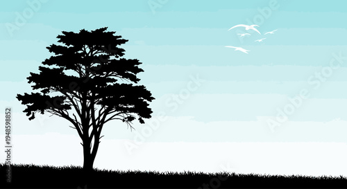 Silhouette of a solitary acacia tree on a grassy hill against a gradient sky with flying birds