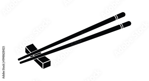 A pair of black chopsticks resting on a chopstick rest isolated on white