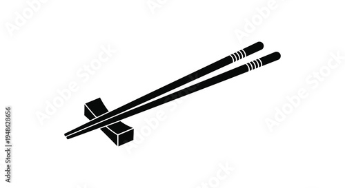 A simple black and white illustration of a pair of chopsticks and a cube