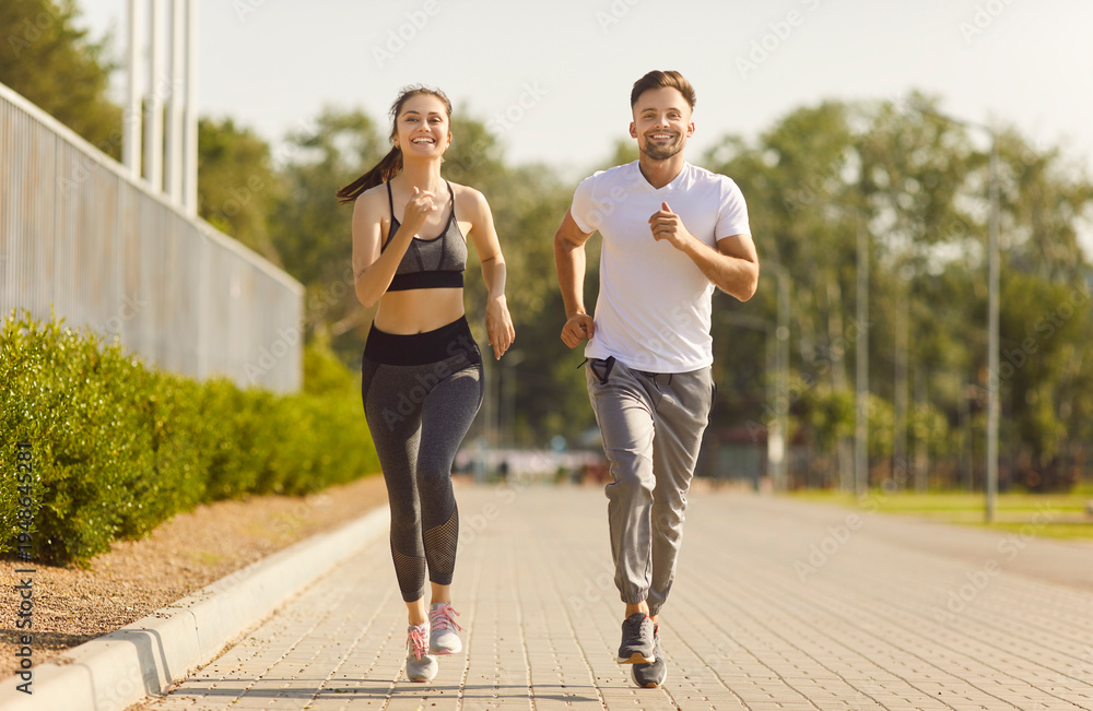 Fototapeta premium City road running and sport exercises of active couple, morning training and jogging of two happy strong runners. Young fit smiling woman and man running marathon. High motivation, workout concept