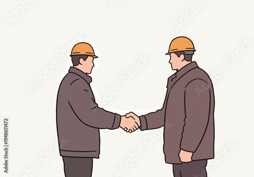 Two construction workers shake hands to celebrate successful project completion at a construction site