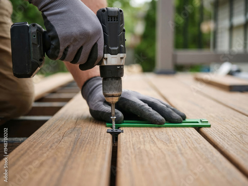 Builder uses drill to secure deck boards during home improvement project in backyard Generative AI