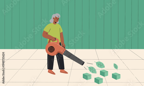 An elderly woman uses a leaf blower to clean a patio, removing fallen leaves. A clean, modern setting with a tiled floor and bright green wall. Focus on outdoor maintenance.