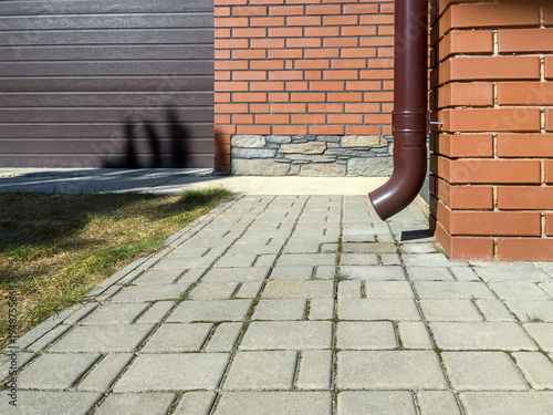 rain gutter downspout on red brick wall. exterior of suburban residential house.