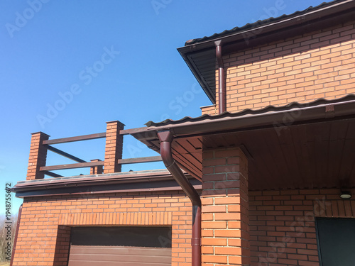 rain gutter system installed on facade of private residential house.